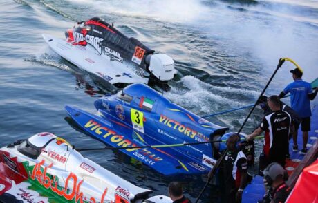 Race teams standby on shore as their powerboats line up in the water