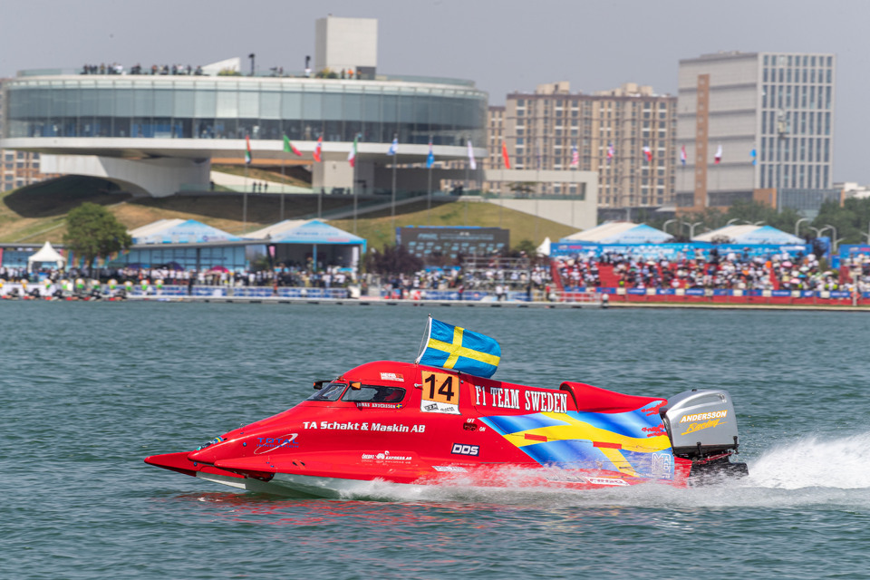 A red powerboat speeds through the water