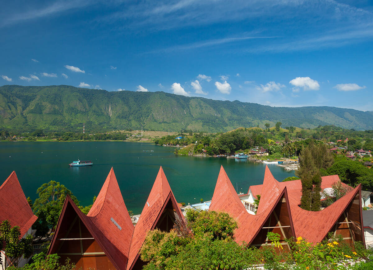 View of Lake Toba with boats and mountains in the horizon